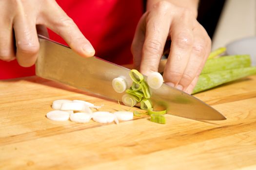 caucasian woman is cutting raw vegetables  on the kitchen table