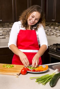 woman talking on the phone while cooking in the kitchen