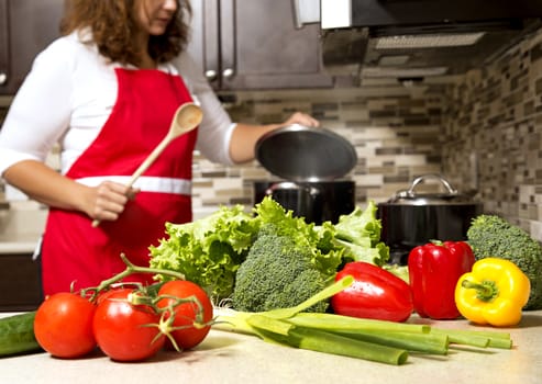 woman cooking with raw vegetables in the kitchen