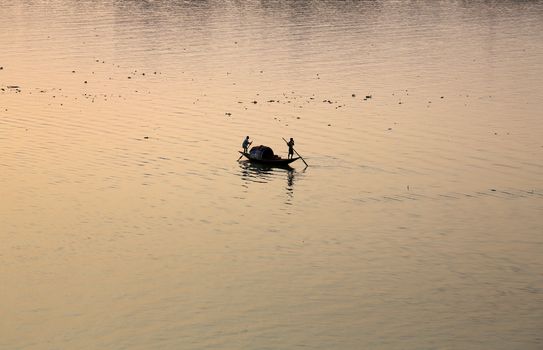 A boat crossing the Hoogly river in Kolkata during sunset