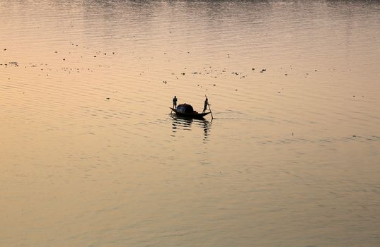 A boat crossing the Hoogly river in Kolkata during sunset