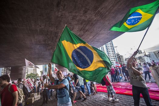 BRAZIL, Sao Paulo: Two protesters wave national flags as hundreds of people demonstrate for the impeachment of President Dilma Rousseff and early elections at Avenida Paulista in Sao Paulo, southern Brazil, on April 1, 2016. Brazilian President Dilma Rousseff is facing possible impeachment by Congress. The effort comes amid an angry public mood over the South American nation's worst recession in decades and a big bribery scandal at the state oil company Petrobras. 