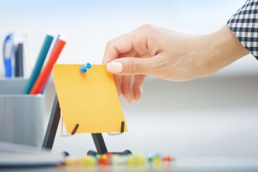 Human hand holding adhesive note with empty space