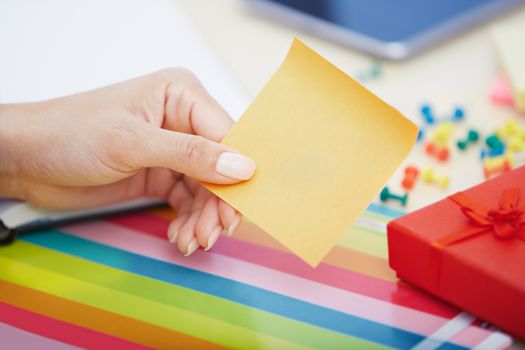 Hand of woman with yellow adhesive note