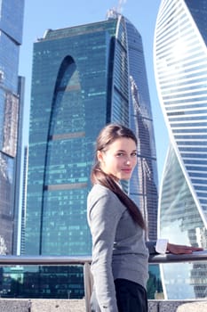 Young beautiful businesswoman outdoors at skyscraper background