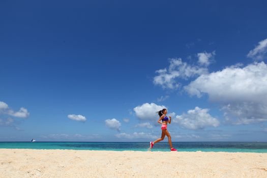 Running woman jogging on beach and sea on background
