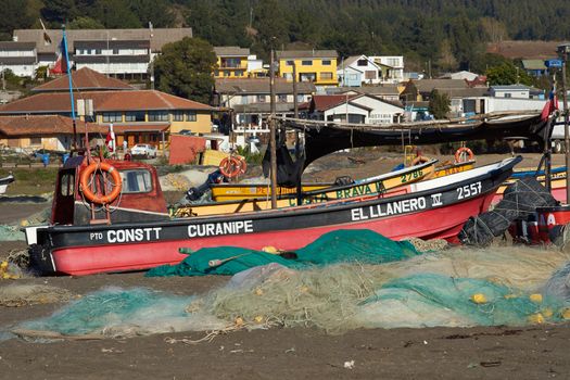Colourful fishing boat and fishing nets on the beach in the small fishing village of Curanipe in the Maule Region of Chile.