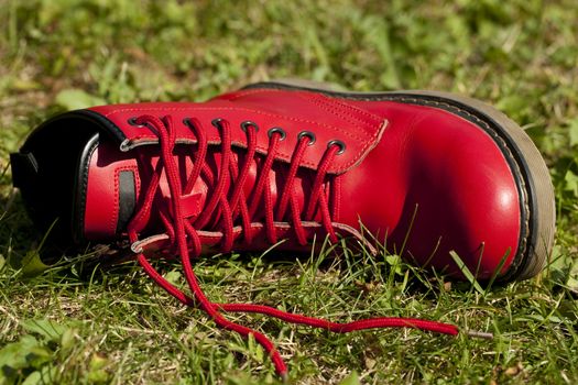 red leather shoe lies on grass