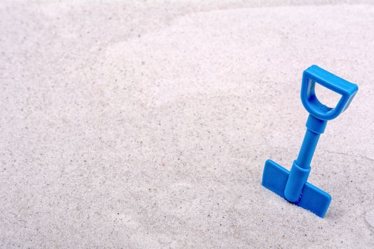 Blue scoop on a grey sand background