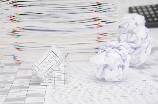 Bankruptcy of house with paper ball on finance account have blur calculator and pile of paperwork as background.