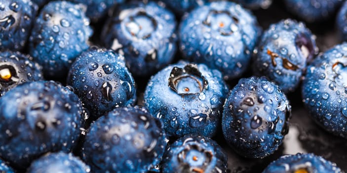Natural background of fresh blueberries with drops close-up
