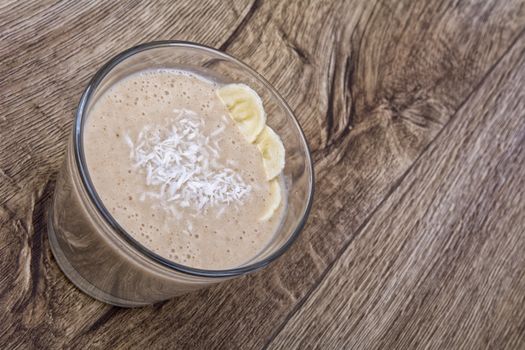 Chocolate drink with coconut and banana on a wooden backhģround