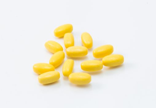 yellow pill isolated on white background close up