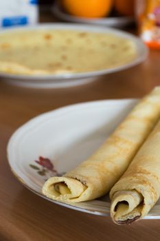 Aranged pancakes on white plate in the kitchen