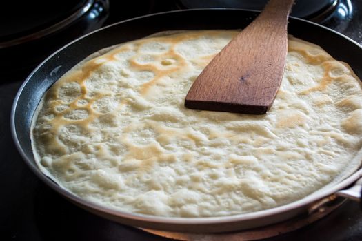 Frying pan with pancake baking on it