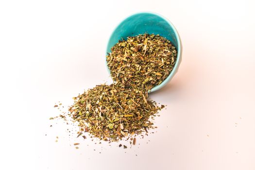 Spilled tea herb in bowl on white background