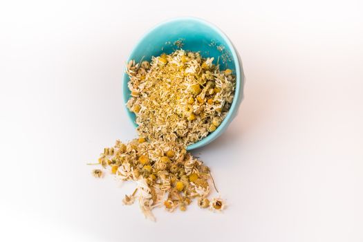 Spilled tea herb in bowl on white background