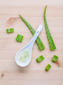 Alternative skin care  aloe vera gel in wooden spoons with aloe vera leaves set up on wooden table.