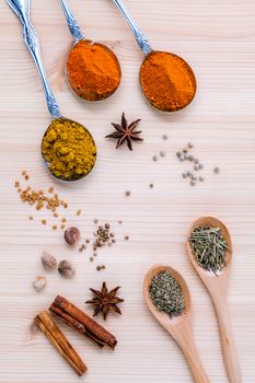 Assorted of dried spices white pepper,cumin ,cinnamon ,thyme ,chili  ,rosemary and fennel seeds with white mortar on wooden background.