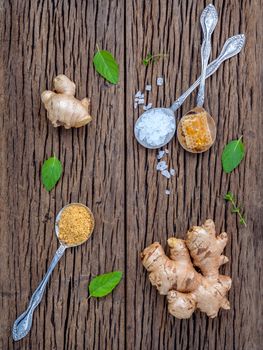 The ingredients of ginger tea with ginger roots , ginger powder , honey and peppermint on rustic wooden table.