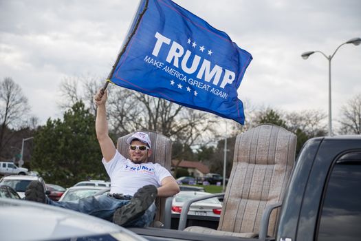 UNITED STATES, West Allis: A Trump supporter waves a blue flag with Donald Trump's political campaign catchphrase on it as Republican presidential candidate Donald Trump speaks to guests during a campaign stop at Nathan Hale High School on April 2, 2016 in West Allis, Wisconsin. Wisconsin voters go to the polls for the state's primary on April 5, 2016.