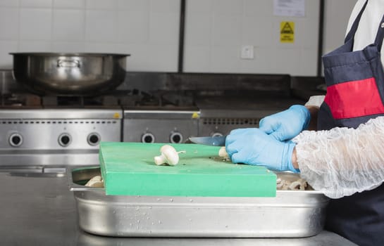 chef preparing food and cutting mushrooms in a restaurant kitchen