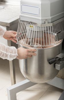 chef is preparing cake mix in industrial bread mixer- kneading machine