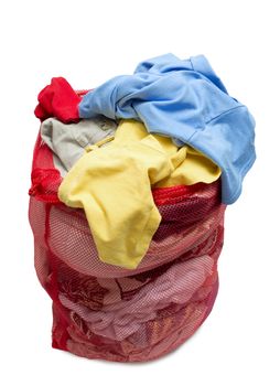 Vertical shot of a bunch of colorful and messy clothes in a red mesh laundry bag.  Isolated on white background