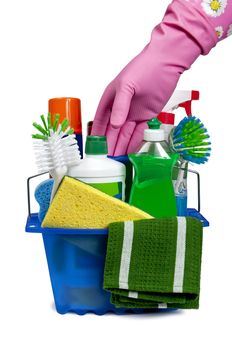 Vertical shot of a hand reaching for basket full of cleaning supplies.