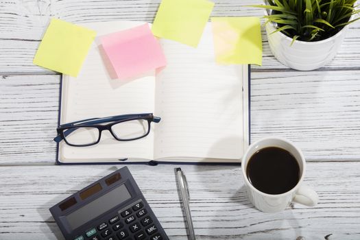 mix of office supplies and gadgets on a wooden table background. view from above