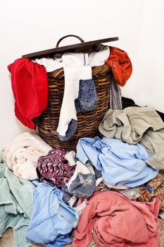 Wicker laundry basket overflowing with dirty clothes.