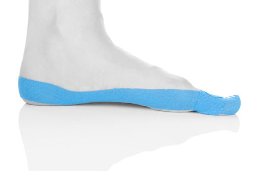 Therapeutic tape on female foot isolated on white background. Chronic pain, alternative medicine. Rehabilitation and physiotherapy.