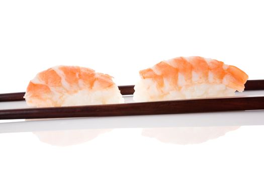 Delicious luxurious nigiri sushi with shrimp and chopsticks isolated on white background. Minimal contemporary asian style.