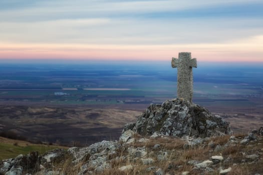 The stone cross in a beautiful sunrise morning at Buzau, Romania.