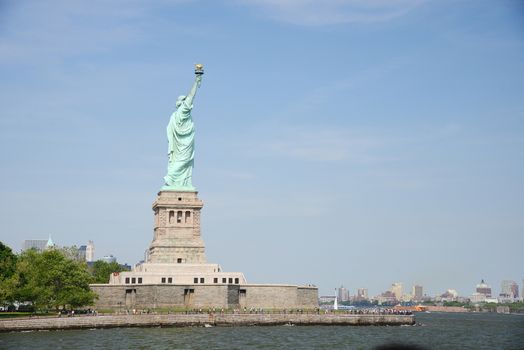 Liberty Statue with buildings in manhattan downtown new york as a background