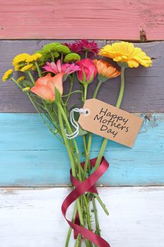 Assorted flowers with gift label on wooden background