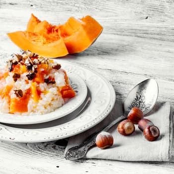 Porridge with pumpkin in stylish wooden bowl, rustic