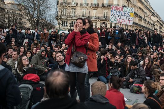 FRANCE, Paris: A woman addresses to a crowd of people as hundreds of militants of the Nuit Debout or Standing night movement hold a general assembly to vote about the developments of the movement at the Place de la Republique in Paris on April 4, 2016. It has been five days that hundred of people have occupied the square to show, at first, their opposition to the labour reforms in the wake of the nationwide demonstration which took place on March 31, 2016. 