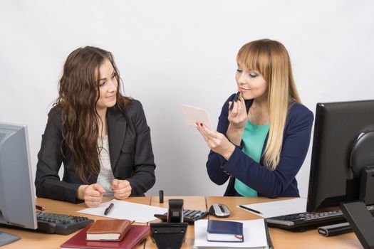 Office employee observes as lipstick colleague sitting beside his desk