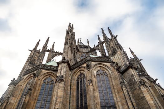 Close up detailed view of historical gothic St. Vitus Cathedral in old town of Prague, found in 1344, on cloudy blue sky background.