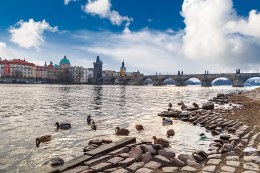 PRAGUE, CZECH REPUBLIC , DECEMBER 31, 2015 : Side view of famous historical Charles Bridge with its gothis architecture in Prague, on cloudy sky background.