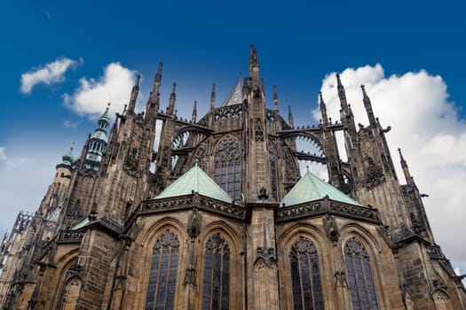 Close up detailed view of historical gothic St. Vitus Cathedral in old town of Prague, found in 1344, on cloudy blue sky background.