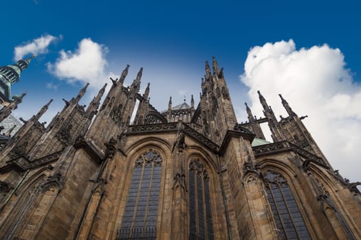 Close up detailed view of historical gothic St. Vitus Cathedral in old town of Prague, found in 1344, on cloudy blue sky background.