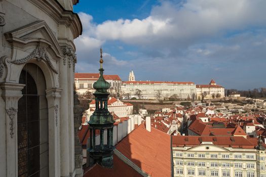 General top view of Prague cityscape view with historical gothic buildings around, on cloudy sky background.