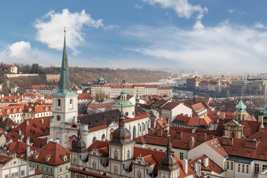 General top view of Prague cityscape view with historical gothic buildings around, on cloudy sky background.