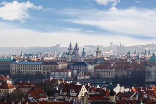 General top view of Prague cityscape view with historical gothic buildings around, on cloudy sky background.