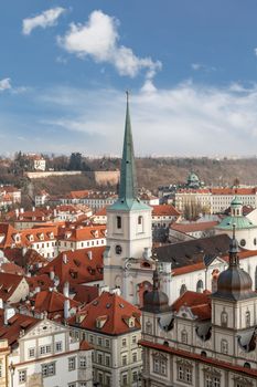 General top view of Prague cityscape view with historical gothic buildings around, on cloudy sky background.