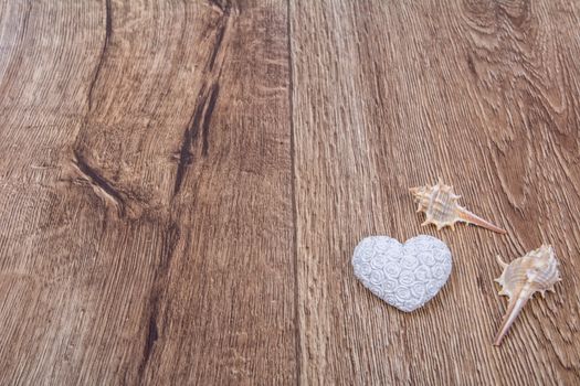 White heart and shells on a wooden background