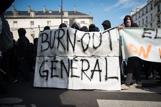 FRANCE, Paris: Protesters hold a banner reading general burn out in Paris on April 5, 2016 as pupils, students and unionists demonstrate against government's planned labour reforms.