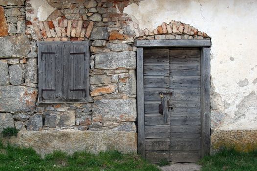 Wooden door and window, on stone facade.